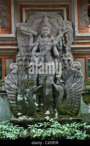 Ein Steinrelief von SARASWATI, die Göttin des Wissens, Musik und Kunst am Eingang des PURA DESA - UBUD, BALI, Indonesien Stockfoto