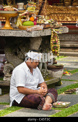 Ein Hindu Mann betet an PURA TAMAN SARASWATI während der GALUNGAN FESTIVAL - UBUD, BALI, Indonesien Stockfoto