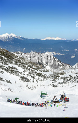 Skifahrer in die Warteschlange für ein Sessellift auf den Vogel-Ski-Zentrum auf der Basis von Kratki Plaz und Konta Pisten in den Triglav National Par Stockfoto