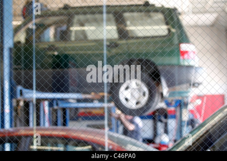 Fahrzeuge auf Aufzüge in Mechanik Garage, gesehen durch Sicherheit (Fokus auf Glas und Embeded Draht) Glasscheibe vom Wartebereich Stockfoto
