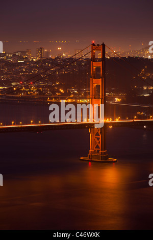 Weiche Twilight Blick auf leuchtende Golden Gate Bridge und entfernten San Francisco spiegelt sich in seidig weiche Bucht Wasser unten Stockfoto