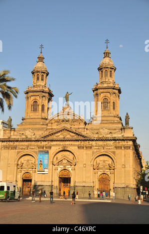 Blauer Himmel Mond Morgen Sonne gelb-braune Fassade Metropolitan Cathedral, Menschen und Polizei van, Plaza de Armas, Santiago, Chile Stockfoto