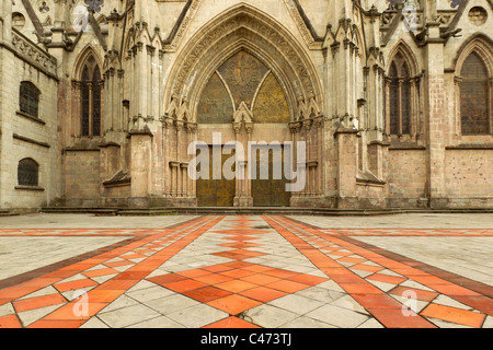 Das Bild zeigt die Vorderfassade einer gotischen Steinkathedrale mit einem großen spitzen Bogeneingang mit komplizierten Schnitzereien und zwei dunklen, verwitterten Holztüren. Über den Türen befindet sich ein Stockfoto