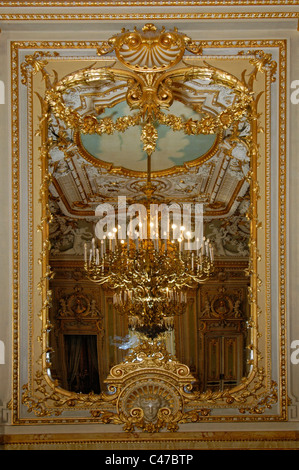 Spiegelung des Leuchters auf vergoldeten Spiegel im Ballsaal im Palazzo Parisio aus dem 17. Jahrhundert, der auch als Palazzo Scilluna bekannt ist, und offiziell Palazzo Parisio und Gärten, ein Palast in Naxxar, einer Stadt im Norden von Malta Stockfoto