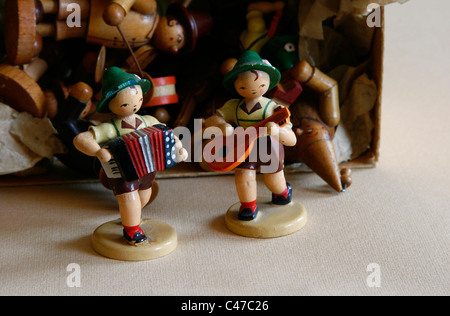 Zwei kleine Holz geschnitzten Figuren der Dregeno Seiffen eG wie Musiker mit anderen Puppen, Deutschland vor einer Box angezeigt. Stockfoto