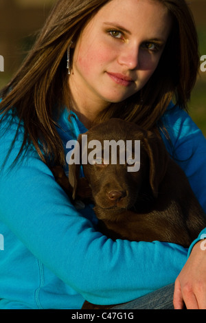 Junge Frau und Labrador Retriever Welpen Stockfoto