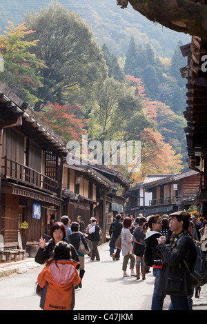 Besucher erkunden Geschäfte und Sehenswürdigkeiten entlang der Nakasendo post Road, Tsumango, Kiso-Tal, Nagano-Präfektur, Honshu, Japan. Stockfoto