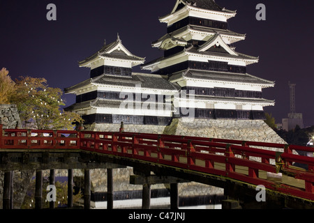 Matsumoto Castle, rote Brücke und Baum mit Schlafplatz weiße Reiher in der Nacht in Matsumoto, Nagano, Japan. Stockfoto