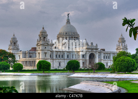 Victoria Memorial Hall, Kalkutta, Kolkata im Abendlicht zeigen Queen es Garden im Vordergrund mit grünem Rasen, Bäume und Teich Stockfoto