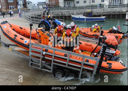 RNLI Rettungsboote von Traktoren gezogen und ins Leben gerufen vom Kai im Hafen von Littlehampton auf den Fluss Arun UK Stockfoto