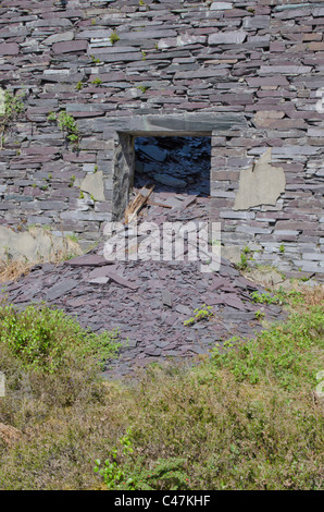 Haufen von Schiefer in eine offene Tür von einem zerstörten Gebäude im Dinorwig Schiefer mir, Snowdonia, North Wales, UK Stockfoto