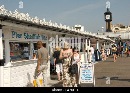 EAST SUSSEX; BRIGHTON; PROBIEREN DIE KÖSTLICHKEITEN DES PIERS; AUSFLÜGLER AUF DEM PIER AM UFER EIN OSTERN URLAUB Stockfoto