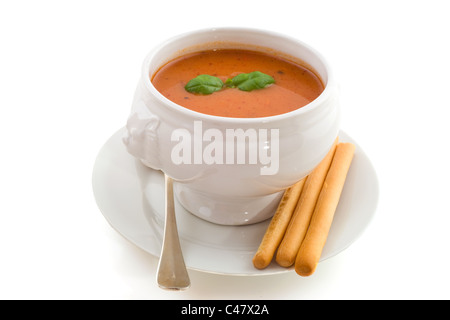 Tomatensuppe mit Basilikum und Brot-Sticks isoliert auf weißem Hintergrund Stockfoto