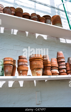 Alten Terrakotta-Töpfe auf den Regalen in restaurierten viktorianischen Gewächshaus in UK Stockfoto