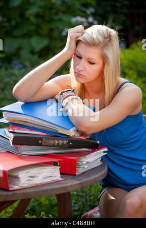 Junges Mädchen mit Revision im Garten mit Akten und Bücher bereit, für Prüfungen lernen betonte Stockfoto