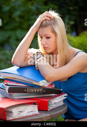 Junges Mädchen mit Revision im Garten mit Akten und Bücher bereit, für Prüfungen lernen betonte Stockfoto