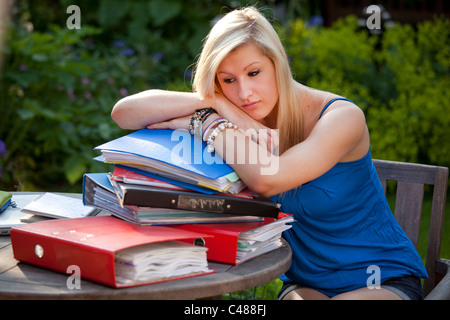 Junges Mädchen mit Revision im Garten mit Akten und Bücher bereit, für Prüfungen lernen betonte Stockfoto