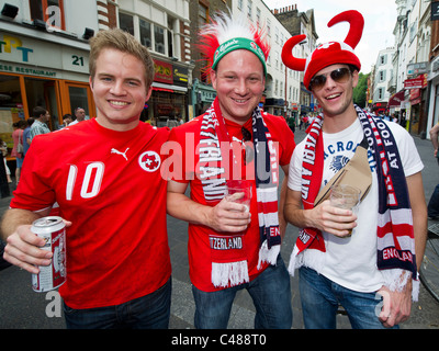 Schweizer Fußball-Fans genießen die Sonne und das Bier in der Nähe von Leicester Square in London vor dem Schlafengehen ihre Teamplay England sehen Stockfoto