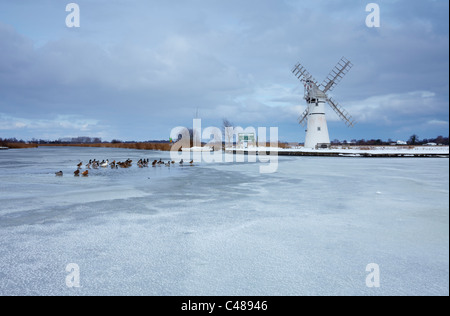 Eine teilweise gefrorenen Fluß Thurne mit Thurne Windmühle im Hintergrund, Norfolk Broads Stockfoto