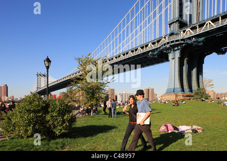 Menschen auf dem Rasen unter der Manhattan Bridge, New York City, USA Stockfoto