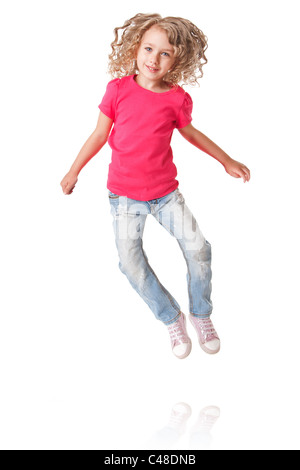 Niedliche glücklich lächelnd isoliert von Freude Mädchen mit Fersen zusammen in rosa Hemd und Jeans, springen. Stockfoto