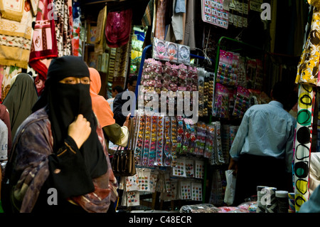 Markt-Szenen in Kairo, Ägypten. Eine verschleierte Frau zu Fuß durch einen engen Markt-Straße. Stockfoto