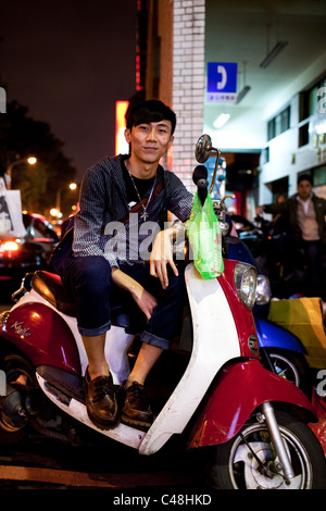 Porträt eines jungen Mannes auf seinem Roller auf der Shida Straße Nachtmarkt, Taipei, Taiwan, 7. November 2010. Stockfoto