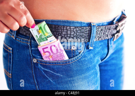 Mädchen nimmt etwas Geld aus ihrer Jeans-Fronttasche Stockfoto
