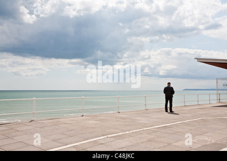 Einsamer Mann am Meer. St Leonards On Sea, Hastings, Sussex, England Stockfoto