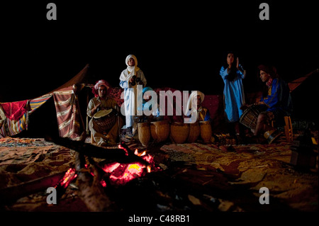 Lokalen Stammesangehörigen singen und tanzen in der Nähe von Beduinen Lagerfeuer in der großen offenen Wüste Sahara. Stockfoto