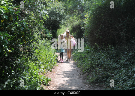 Eine Mutter und Tochter im Urlaub zu Fuß auf einem Weg in Cornwall Stockfoto