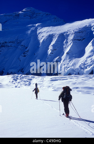 Zwei Männer Skitouren unter sonnigen Himmel im Schatten der Nordwand des Mount Everest. Stockfoto