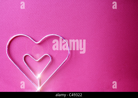 Metal Heart in den fuchsia Hintergrund Stockfoto