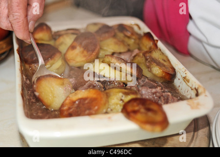 Weibliche ältere OAP, serviert auf einem Lancashire Hotpot zum Abendessen UK Stockfoto