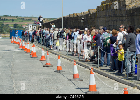 Eine lange Schlange von Menschen auf Penzance Pier warten auf die Scillonian III Bord der Fähre zu den Isles of Scilly. Stockfoto