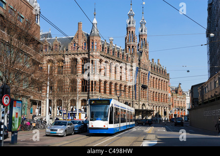 Straßenbahn vor der Magna Plaza Shopping Centre (ehemals ein Postamt), Nieuwezijds Voorburgwal, Amsterdam, Niederlande Stockfoto