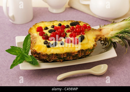 Gefüllte Ananas mit Creme und Beeren... Rezept zur Verfügung. Stockfoto