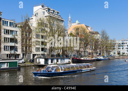 Sightseeing-Bootsfahrt auf dem Fluss Amstel nahe Waterlooplein, Amsterdam, Niederlande Stockfoto