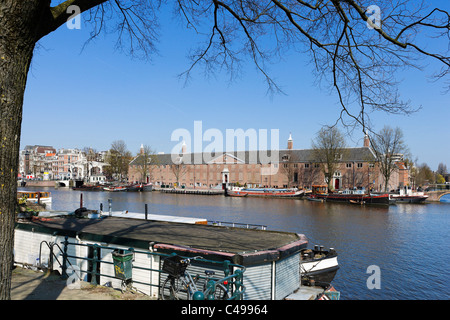 Hausboot auf dem Fluss Amstel vor der Eremitage und Magere Brug, Amsterdam, Niederlande Stockfoto