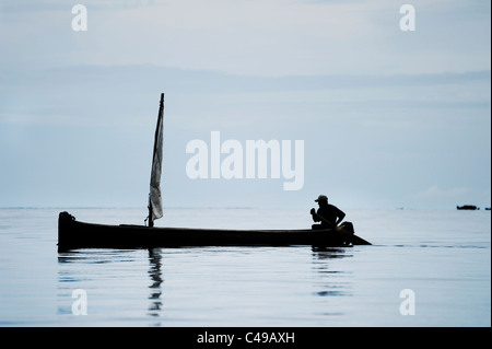 Ansicht eines indigenen Kuna Mannes sein Ruderboot vor einer Insel in San Blas Archipel der Küste von Panama in Mittelamerika Stockfoto