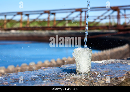 Glas mit Flüssigkeit fließen in einer Wasseraufbereitungsanlage Stockfoto