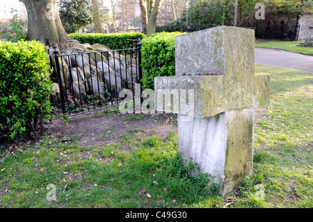 Grabsteine oder Grabsteine um The Hardy Baum mit eindrucksvollen Kreuz geformte Stein in Forground St. Pancras Churchyard, St Pancr Stockfoto