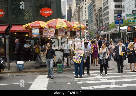 Anbieter und Fußgänger verstopft die Straßenecken in Midtown Manhattan. 5th Ave & 46th St. Stockfoto