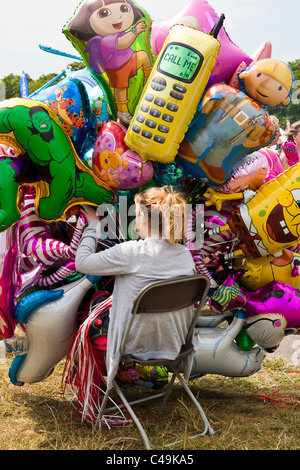 Junge Frau, die Helium-Ballons auf der Cambridge Strawberry Fair 2011 zu verkaufen Stockfoto