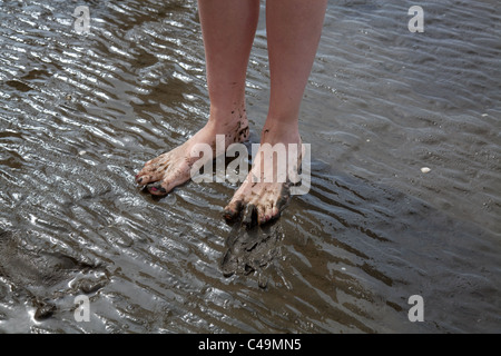 schlammige Füße bei einem Spaziergang im Wattenmeer, dem UNESCO-Weltkulturerbe an der Nordsee in Deutschland Stockfoto