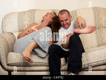 Mann kitzeln Frau Fuß Stockfoto