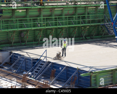 Mann arbeitet auf der Oberfläche des neu Gussbeton von was eine neue Kai der Tiefseehafen in Rotterdam NL wird Stockfoto