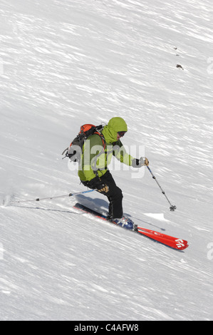 Ein Mann Ski tragen einen Rucksack abseits der Piste in frischem Schnee unter blauem Himmel am Mount Damavand Teil des Elburs-Gebirges Iran Stockfoto