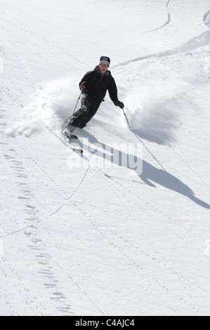 Ein Mann Telemarken im tiefen frischen Pulverschnee unter einem strahlend blauen Himmel in Dizin Iran Stockfoto