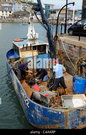 Besatzung eines Fischerbootes Einbau des Motors, unter Deck Brixham Devon England uk Stockfoto